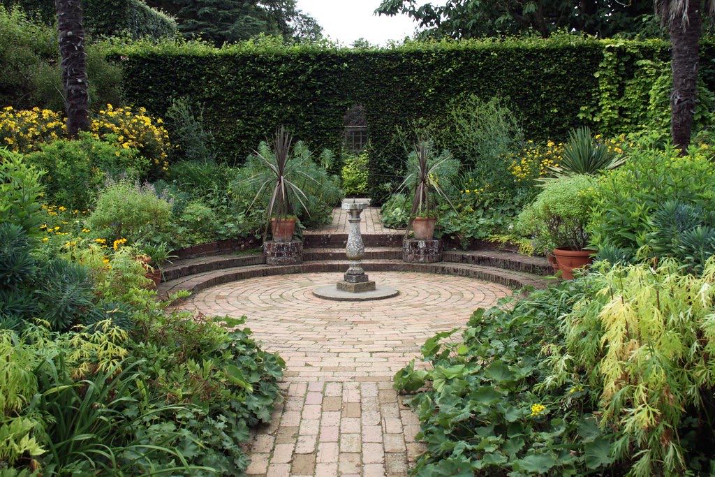 A brick-paved circular patio and garden path, clean and clear of moss